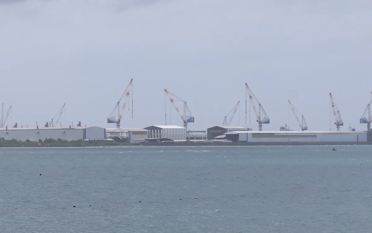 Shipyard gantry cranes and assembly halls of the West Cebu Industrial Park at Buanoy, Balamban, seen across the water of the Tañon Strait