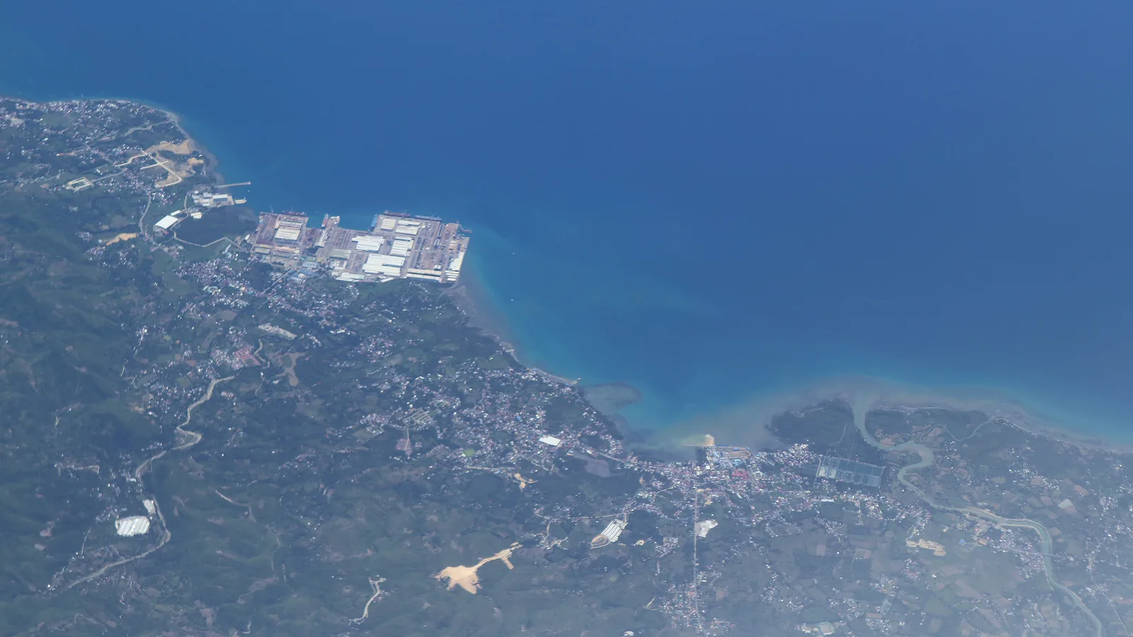 Aerial view of Balamban, Cebu, showing the shipyards on the point, the town spread along the coast and the green highlands rising behind
