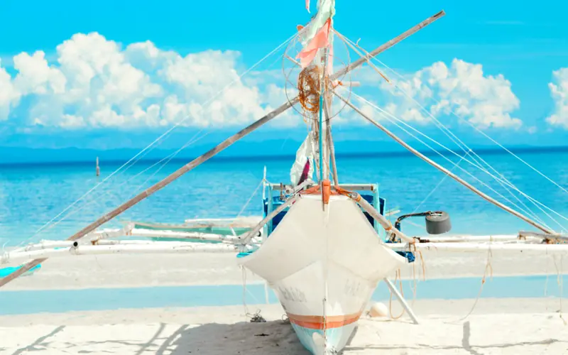 Powder-white sand and turquoise shallows with a traditional banca boat on Bantayan Island, Cebu