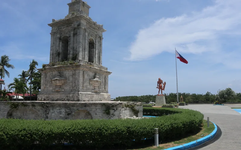 The Magellan marker and the bronze Lapu-Lapu monument with the Philippine flag at the Mactan Shrine, Punta Engano, Lapu-Lapu City