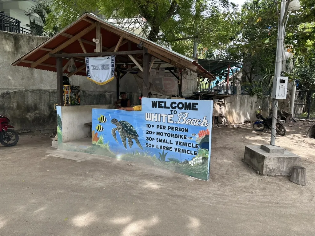 The signposted entrance gate to White Beach (Basdaku), Moalboal, Cebu, listing the per-person and vehicle parking fees