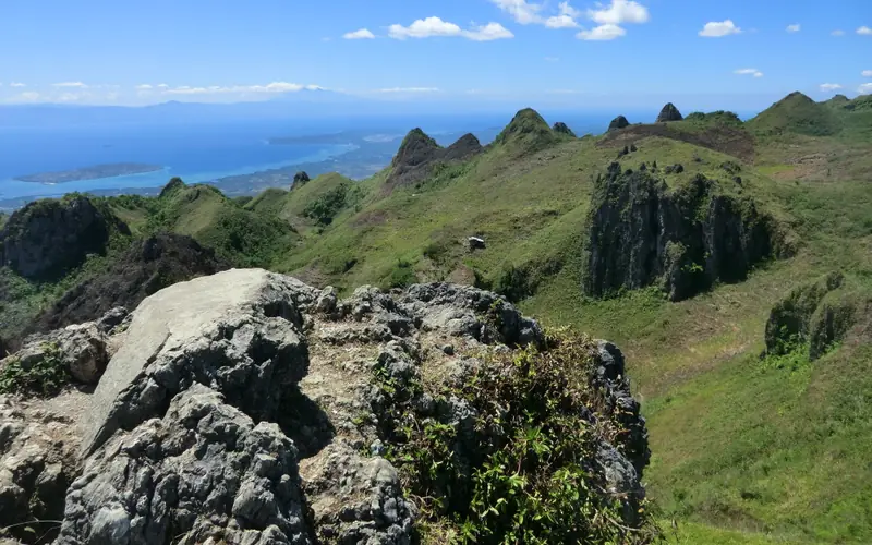 The jagged green peaks of Osmeña Peak in Dalaguete, Cebu, overlooking the distant sea