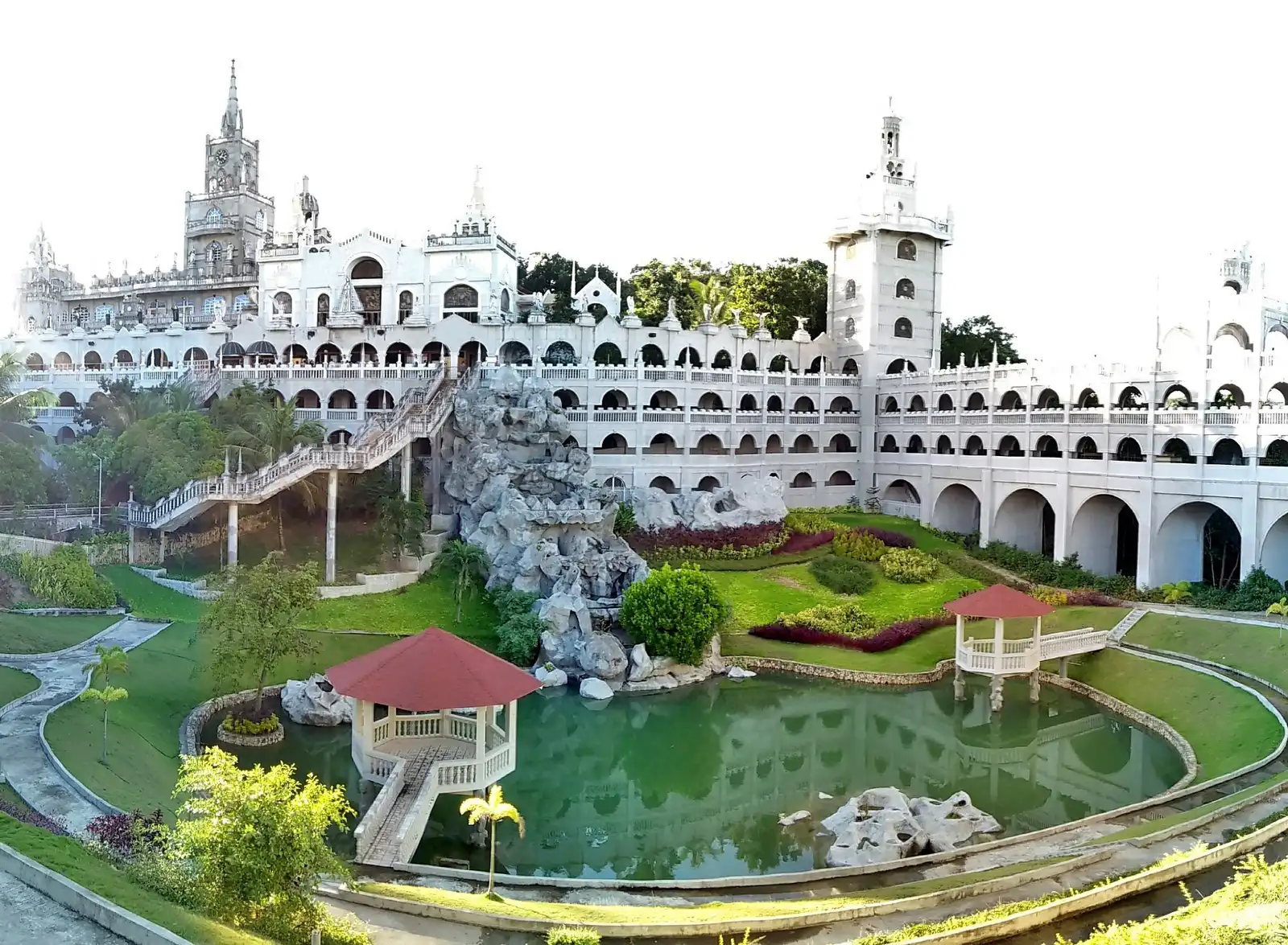 Photo: Jennifer Bauzon / CC BY-SA 4.0, via Wikimedia Commons The arched arcades and manicured gardens of Simala Shrine in Sibonga, Cebu