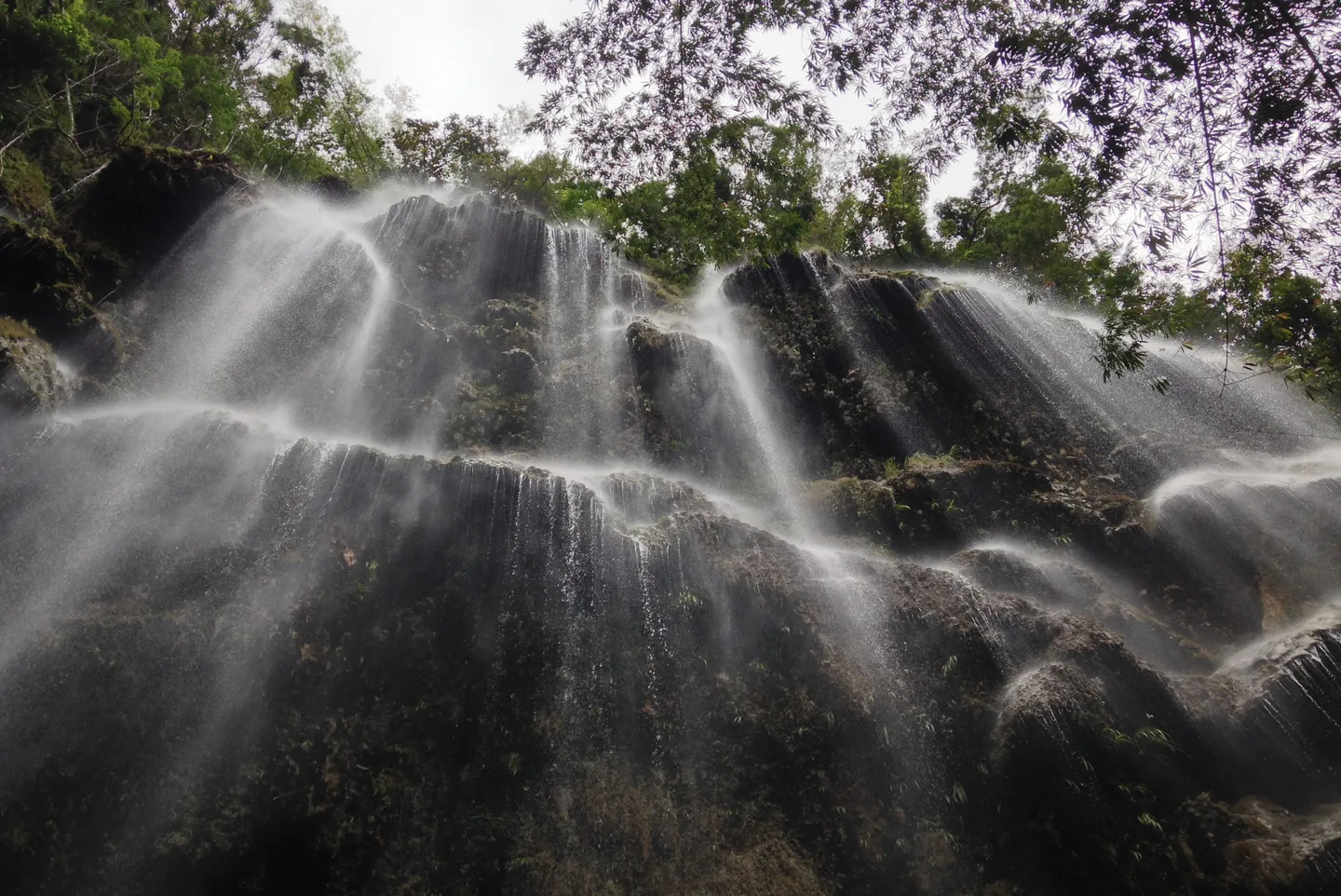 Photo: Marvin Galang / CC0 1.0, via Wikimedia Commons The wide curtain of Tumalog Falls spraying down a mossy limestone face near Oslob, Cebu